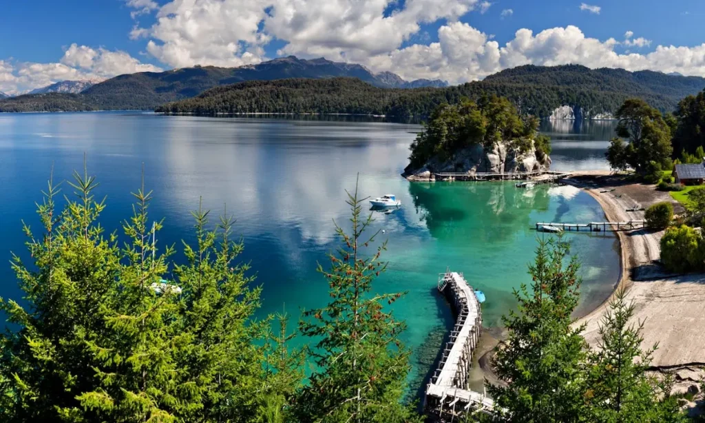 Vista panorámica del lago Nahuel Huapi en Bariloche con muelles y montañas nevadas